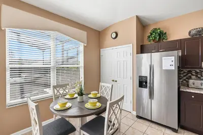 a kitchen with a table and a refrigerator at 8157 Fan Palm in Kissimmee
