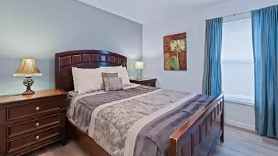 a bedroom with a bed and a dresser with a lamp at 8159 Fan Palm in Kissimmee