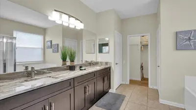 a bathroom with two sinks and a large mirror at 8176 Fan Palm in Kissimmee