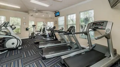 a gym with several tread machines in a room at 8190 Fan Palm in Kissimmee