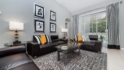 a living room with two leather couches and a table at 8208 Fan Palm in Kissimmee