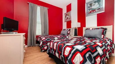 a red bedroom with two beds and a tv at 8208 Fan Palm in Kissimmee