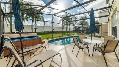 a patio with a table and chairs and a swimming pool at 8008 King Palm in Kissimmee