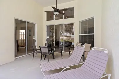 a living room with purple chairs and a table and windows at 8038 King Palm in Kissimmee