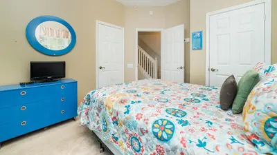 a bedroom with a bed and a blue dresser at 8114 Princess Palm in Kissimmee