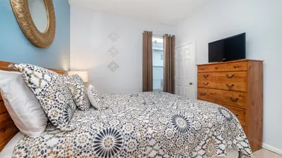 a bedroom with a bed and a dresser with a television at 8135 Sun Palm in Kissimmee