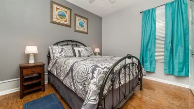a bedroom with a bed and a window with blue curtains at 8136 Sun Palm in Kissimmee