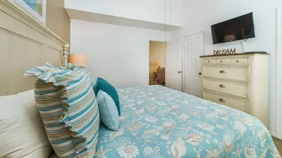 a bedroom with a bed and a dresser with a television at 8137 Sun Palm in Kissimmee