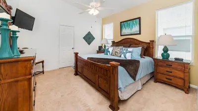 a bedroom with a bed and a dresser and a television at 8137 Sun Palm in Kissimmee