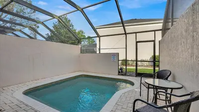 a swimming pool with a table and chairs next to a building at 2326 Silver Palm in Kissimmee