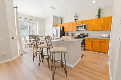 a kitchen with wooden cabinets and bar stools at 2209 Wyndham Palms in Kissimmee