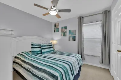 a white bedroom with a bed and a ceiling fan at 2244 Wyndham Palms in Kissimmee