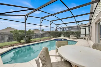 a swimming pool with a table and chairs next to a swimming pool at 2244 Wyndham Palms in Kissimmee