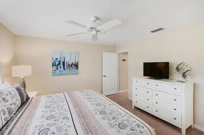 a bedroom with a bed and a flat screen tv at 8883 Candy Palm in Kissimmee