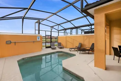 a swimming pool on a patio with a roof at 8883 Candy Palm in Kissimmee