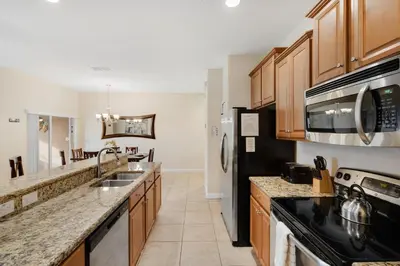 a kitchen with wooden cabinets and a black refrigerator at 8883 Candy Palm in Kissimmee