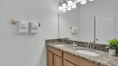 a bathroom with two sinks and a mirror at 8967 Cat Palm in Kissimmee