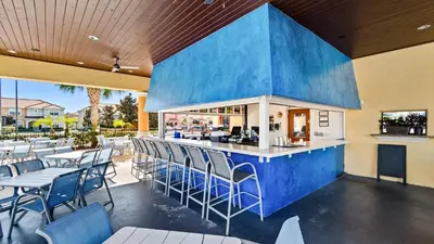 a restaurant with a blue bar with chairs and tables at 8951 Coco Palm in Kissimmee