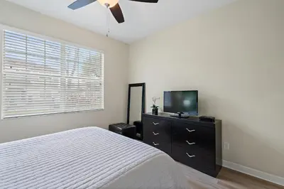 a bedroom with a bed and a flat screen tv at 8949 Cuban Palm in Kissimmee