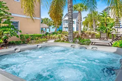 a hot tub in a backyard with palm trees at 8000 Lost Shaker Lane in Orlando