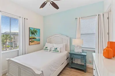 a white bedroom with a bed and a night stand with a lamp at 8000 Lost Shaker Lane in Orlando