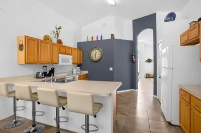 a kitchen with a counter and a sink and a refrigerator at 201 Hideaway beach 4 beds - pool&spa in Kissimmee
