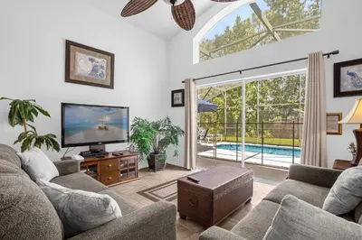 a living room with a tv and a large window at 201 Hideaway beach 4 beds - pool&spa in Kissimmee