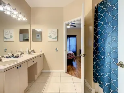 a bathroom with a sink and a large mirror at Beautiful Windsor Palms 4 Bed South Facing Pool villa in Kissimmee