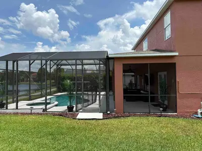 a glass extension of a house with a swimming pool at Villa Madiera 6 bedroom huge house in Kissimmee