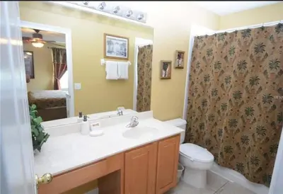 a bathroom with a sink and a toilet and a mirror at Villa Madiera 6 bedroom huge house in Kissimmee