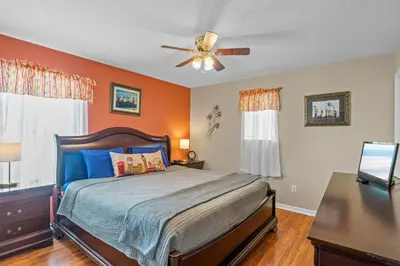 a bedroom with a bed and a ceiling fan at Be-Our-Guest Home! 15 mins to Disney! in Kissimmee