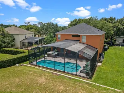 an image of a large house with a swimming pool at Be-Our-Guest Home! 15 mins to Disney! in Kissimmee