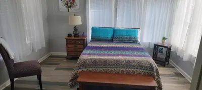 a bedroom with a bed with blue pillows and a chair at Sanford Country Escape Fire Pit, Yard and Wildlife! in Sanford