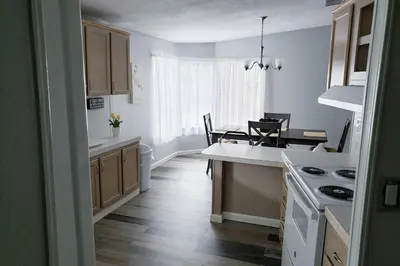 a kitchen with wooden floors and a white counter top at Sanford Country Escape Fire Pit, Yard and Wildlife! in Sanford