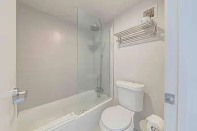 a white bathroom with a toilet and a shower at Travel Lodge by Wyndham 10 min from Disney in Kissimmee