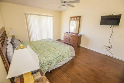 a bedroom with a bed and a dresser and a television at Sweetwater Club 3 Bedroom Condo Resort Pool 9 Miles to Disney in Kissimmee