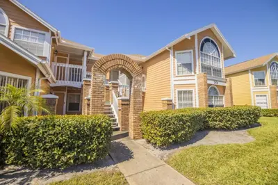 a house with bushes in front of it at Sweetwater Club 3 Bedroom Condo Resort Pool 9 Miles to Disney in Kissimmee