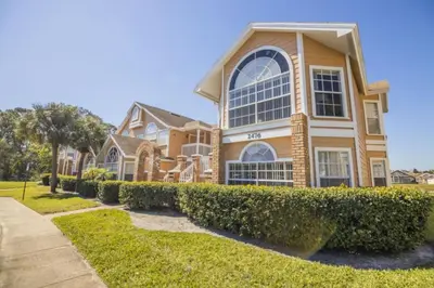 a large house with bushes in front of it at Sweetwater Club 3 Bedroom Condo Resort Pool 9 Miles to Disney in Kissimmee