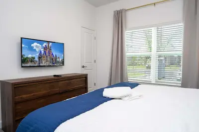 a bedroom with a bed with a tv on the wall at 2681 Stunning home perfect for your family in Kissimmee