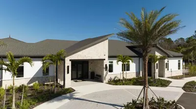 a building with a palm tree in front of it at 2681 Stunning home perfect for your family in Kissimmee