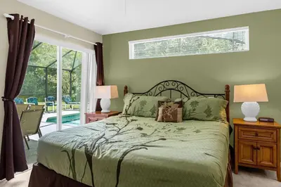 a bedroom with a bed and a sliding glass door at 1061 Lake Berkley 4 Bed with Pool&Spa in Kissimmee