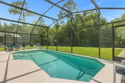 a swimming pool in a house with a glass wall at 1061 Lake Berkley 4 Bed with Pool&Spa in Kissimmee