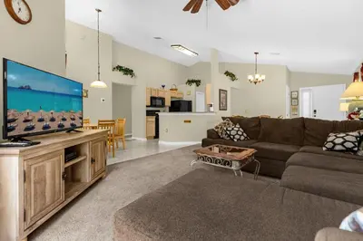 a living room with a couch and a flat screen tv at 1061 Lake Berkley 4 Bed with Pool&Spa in Kissimmee