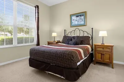a bedroom with a large bed and two night stands at 1061 Lake Berkley 4 Bed with Pool&Spa in Kissimmee