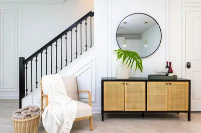 a mirror above a dresser in a living room with a chair at Luxurious Home w Theme Beds & Private Pool in Kissimmee