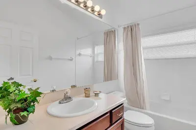 a bathroom with a sink and a toilet and a mirror at 4 bedrooms pool home with water view and short drive from Disney in Kissimmee