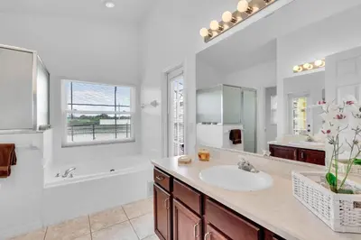 a bathroom with a sink and a tub and a mirror at 4 bedrooms pool home with water view and short drive from Disney in Kissimmee