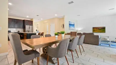 a dining room and living room with a table and chairs at Storey Lake 6BR Cozy Home Private Pool Near Disney in Kissimmee