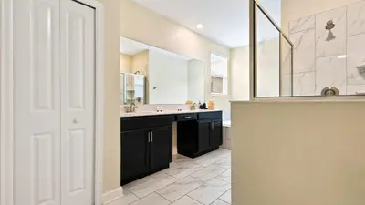 a bathroom with a sink and a large mirror at Storey Lake 6BR Cozy Home Private Pool Near Disney in Kissimmee
