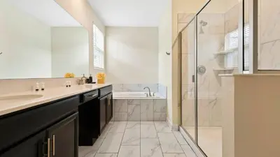 a bathroom with a tub and a sink and a shower at Storey Lake 6BR Cozy Home Private Pool Near Disney in Kissimmee